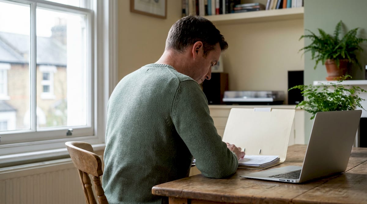 A parent sits at a desk preparing an appeal from a folder of documents.