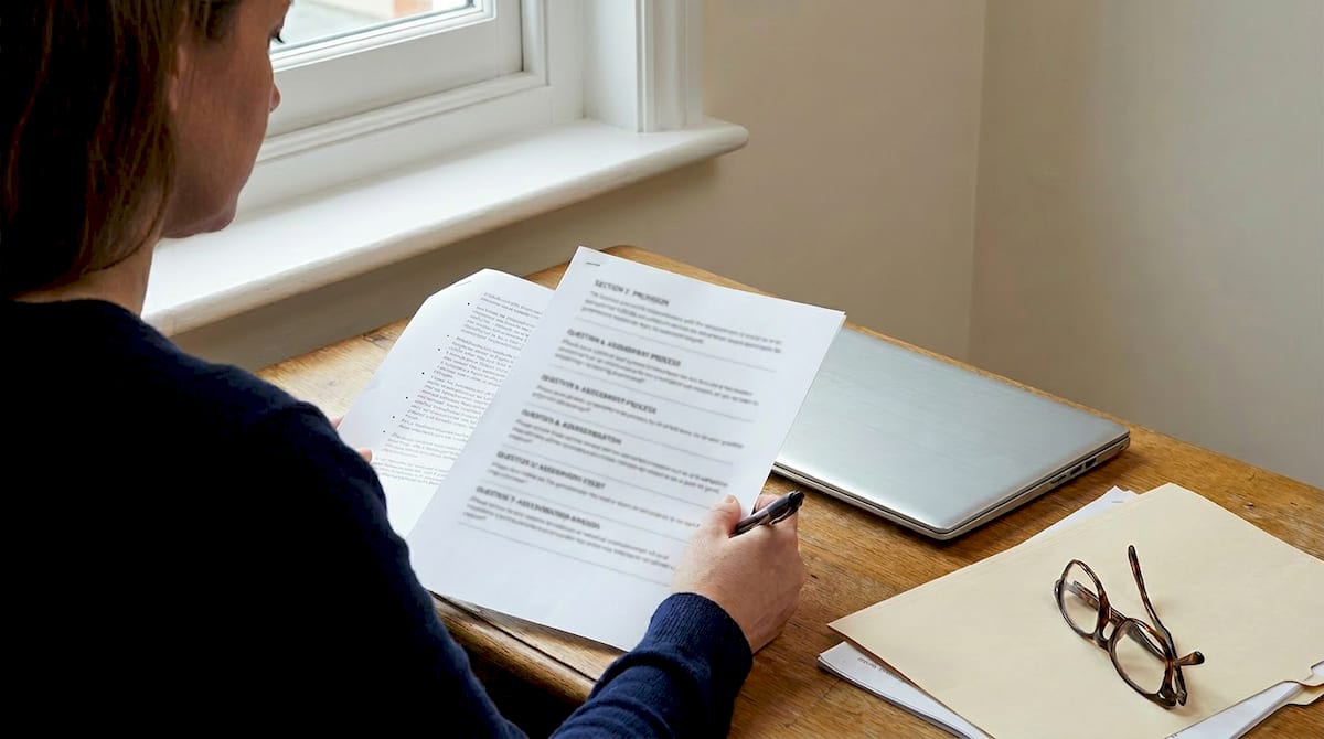 A parent writing a response to a SEND consultation, with a highlighted printed document and a laptop. AI-generated illustration.